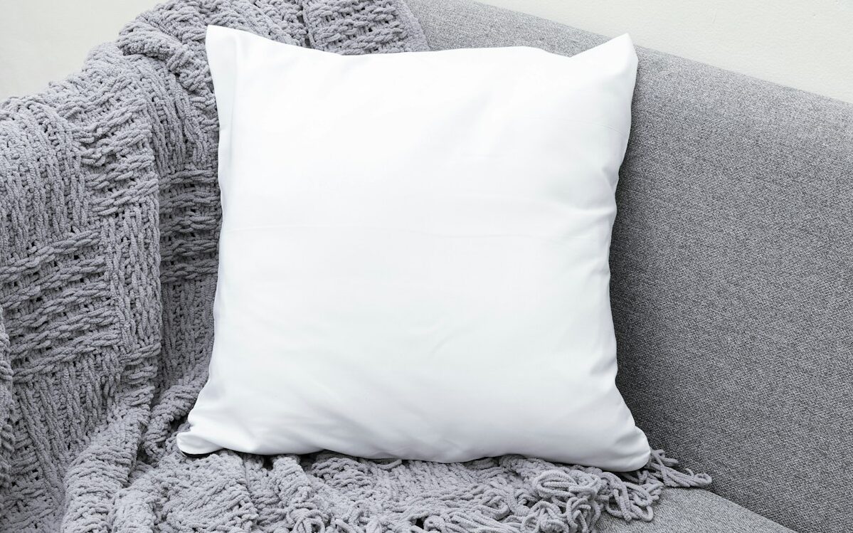 white throw pillow on gray sofa